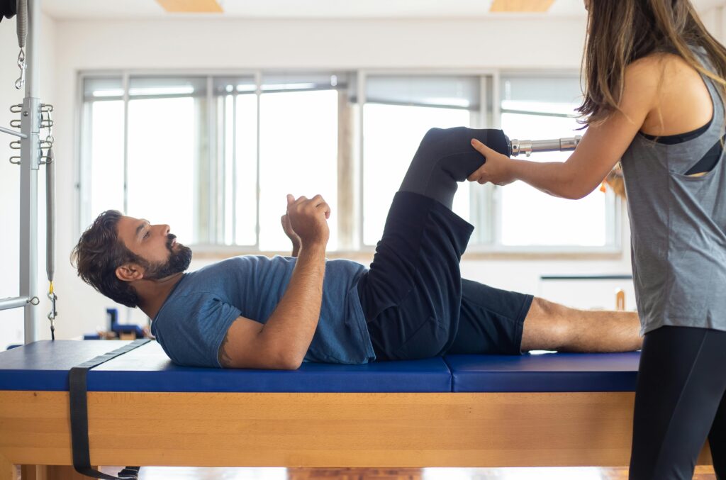 Man and woman engaging in a physical therapy session, focusing on prosthetic leg recovery and rehabilitation.